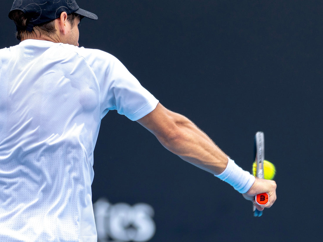 האביזרים שיביאו אותך לשלב הבא: מחבטים, כובעים, משקפי שמש ועוד - שחקן טניס תופס מחבט.