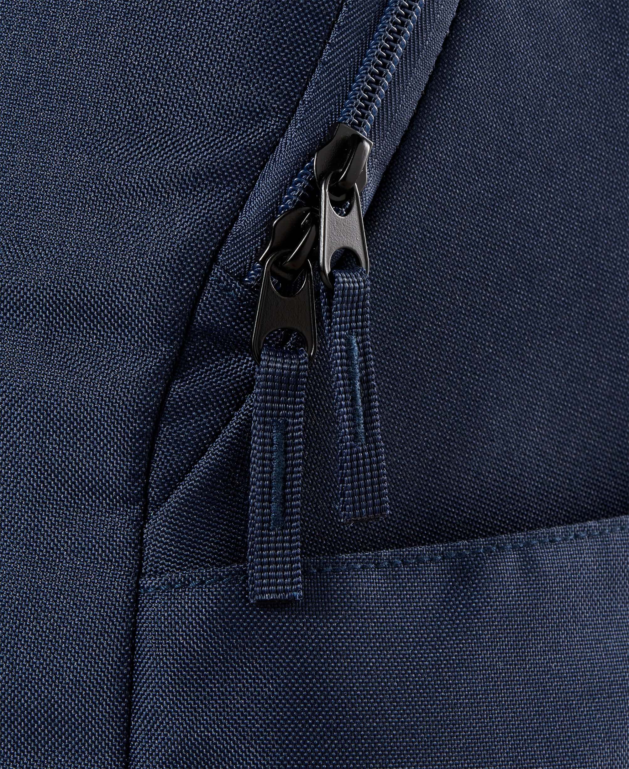 תקריב על רוכסן תיק טניס וילסון | Team Backpack Wilson אפור, עם טקסטורה בד עמוקה.